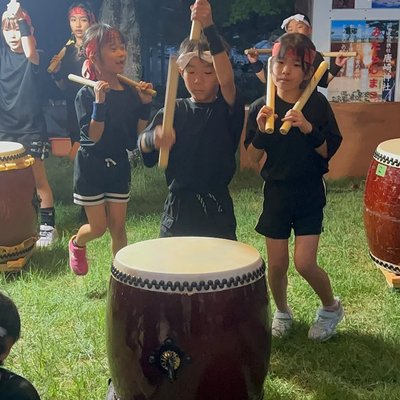 バチを振り上げて太鼓を打つ子どもたち