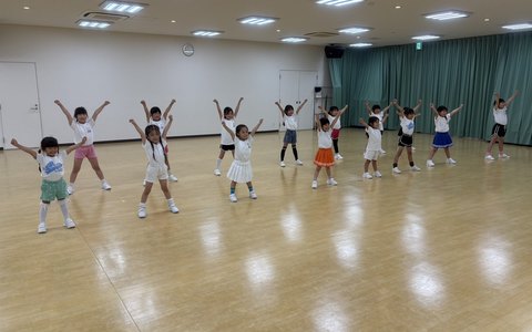 両手を上げてポーズをとるキッズクラスの子どもたち